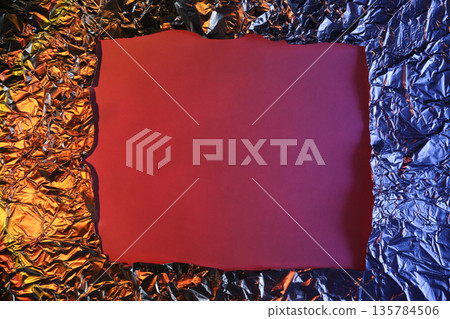 Crumpled metallic foil creating textured frame around purple background with copy space Crumpled metallic foil creating textured frame around purple background with copy space 135784506