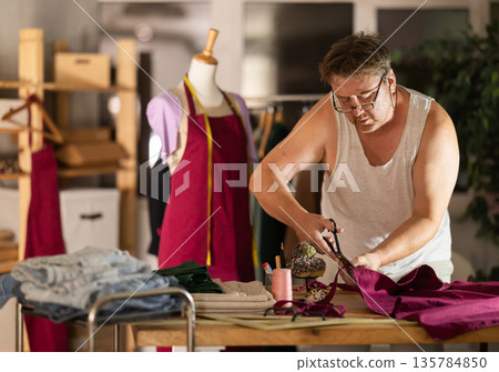 Man seamstress work with scissors and cutting 135784850