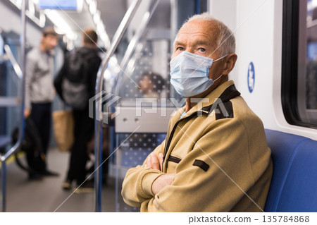 Old man in face mask sitting in subway car 135784868