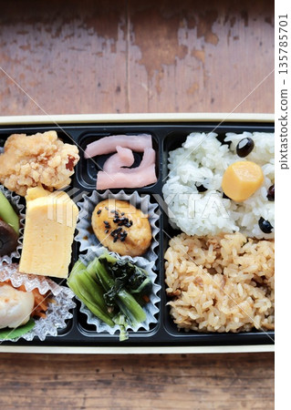 A takeaway Japanese bento box with a wide variety of side dishes 135785701