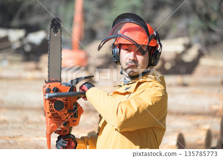 A Japanese man holding a chainsaw at the site. Photo courtesy of Tama Forest Center Cooperative Association. 135785773