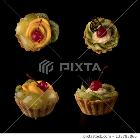 Fruit dessert cake with cherries, shekolad, grapes sponges, kiwi slices and orange slices on a black background isolated, collage 135785866