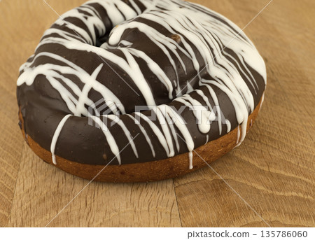 bun covered with chocolate, on a wooden board bun covered with chocolate, on a wooden board 135786060