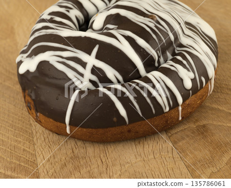bun covered with chocolate, on a wooden board bun covered with chocolate, on a wooden board 135786061