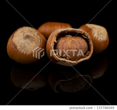 hazelnut fruits, hazelnuts on a black background with reflection hazelnut fruits, hazelnuts on a black background with reflection 135786089