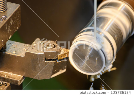 Close Up of Lathe Machine Finishing Metal Shaft with Liquid Coolant 135786184