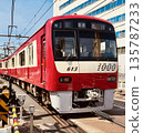 A red Keikyu Railway 1000 series train running under clear skies 135787233