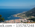 A beautiful blue ocean with a small town in the background 135787248