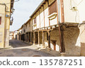 A narrow street with a building on the right side 135787251
