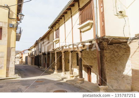 A narrow street with a building on the right side 135787251