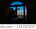 A man and a child are pointing out a beautiful view from a window 135787255