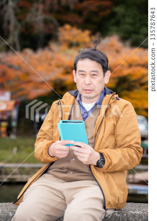 Middle-aged people checking their schedule books 135787643
