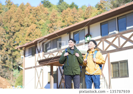 一群男人站在旅館外排成一排,抬頭望向。 一群男人站在旅館外排成一排,抬頭望向。 135787939