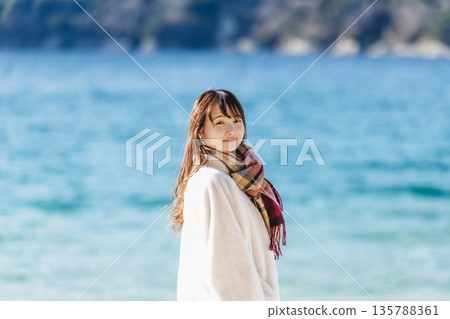 A woman standing by the sea 135788361