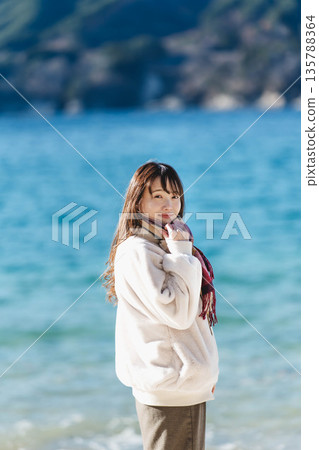A woman standing by the sea 135788364