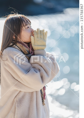 A woman standing by the sea 135788367