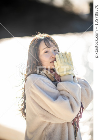 A woman standing by the sea 135788370