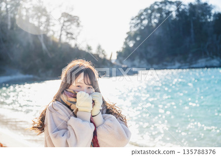 A woman standing by the sea A woman standing by the sea 135788376