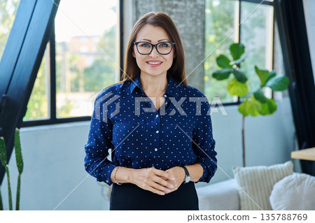 Portrait of middle-aged confident business woman looking at camera Portrait of middle-aged confident business woman looking at camera 135788769