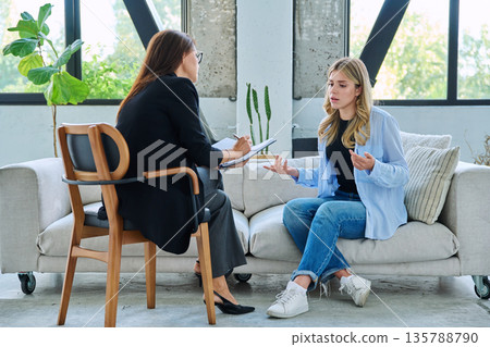 Young woman in psychological therapy session talking with professional mental health therapist Young woman in psychological therapy session talking with professional mental health therapist 135788790
