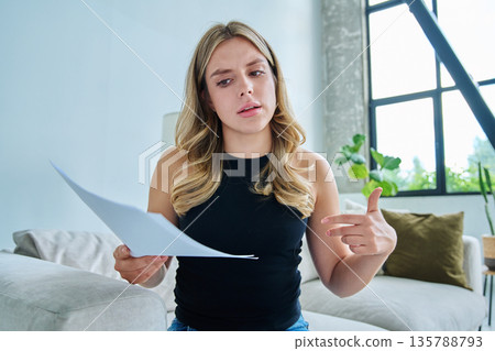 Webcam view young serious woman with business papers having video 135788793