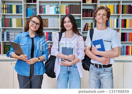 Portrait of two teenagers students with female teacher, tutor in library Portrait of two teenagers students with female teacher, tutor in library 135788859