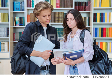 Portrait of two teenage students classmates boy and girl talking at school Portrait of two teenage students classmates boy and girl talking at school 135788861
