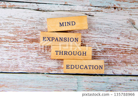 Wooden blocks display the phrase Mind Expansion Through Education on a rustic wooden surface, suggesting knowledge unlocks potential and fosters growth 135788966