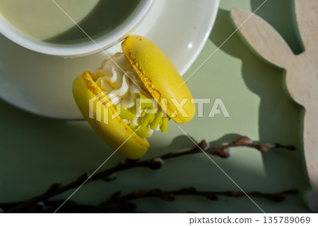 Easter bunny holiday decor Nutrient-rich matcha drink with macaron dessert and trendy deep shadows on soft colored background. Morning beautiful breakfast present gift idea. Vibrant creative colors 135789069