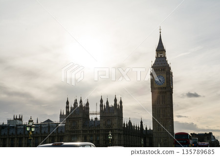 London's Westminster and its large clock tower, Big Ben, backlit under a slightly cloudy sky 135789685