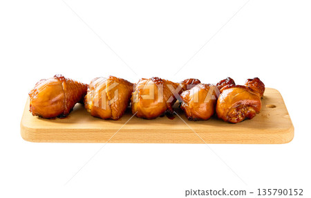 Grilled chicken drumsticks on a cutting board isolated. Fried crispy chicken legs on a cutting board isolated. Grilled chicken drumsticks on a cutting board isolated. Fried crispy chicken legs on a cutting board isolated. 135790152