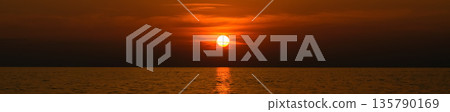 Red sunset over the ocean. Vibrant sunset over the ocean with warm orange and red hues reflecting on water. Red sunset over the ocean. Vibrant sunset over the ocean with warm orange and red hues reflecting on water. 135790169