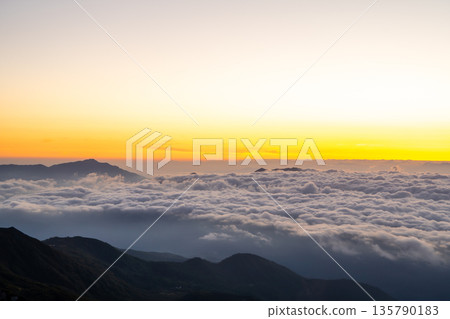 Magic hour view of Mt. Myoko and the sunrise from Mt. Shirouma. Traverse hike from Mt. Shirouma to Mt. Yukikura in the Northern Alps. Magic hour view of Mt. Myoko and the sunrise from Mt. Shirouma. Traverse hike from Mt. Shirouma to Mt. Yukikura in the Northern Alps. 135790183