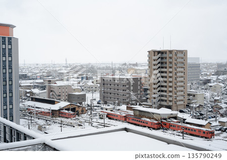 積雪覆蓋的JR高岡車站和一棟建築物的屋頂 積雪覆蓋的JR高岡車站和一棟建築物的屋頂 135790249