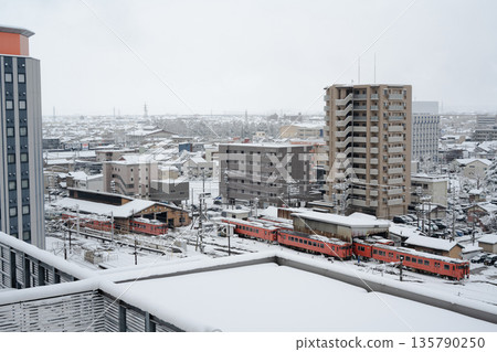 Snow-covered JR Takaoka Station and the rooftop of a building 135790250