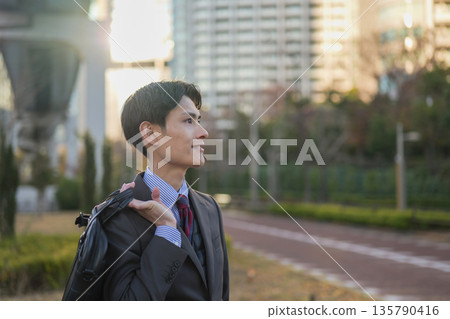 Profile of a businessman looking to the future in the gentle light of the evening Profile of a businessman looking to the future in the gentle light of the evening 135790416