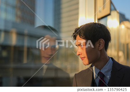 Close-up of a businessman's profile as he casts a sharp gaze and plans a strategy Close-up of a businessman's profile as he casts a sharp gaze and plans a strategy 135790425