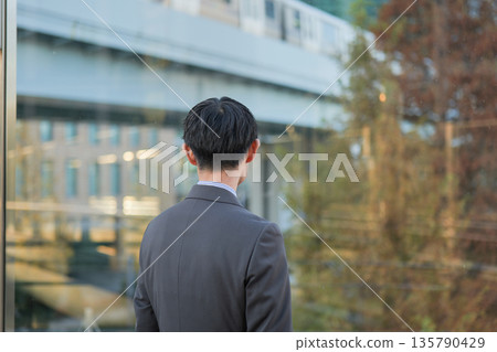 Rear view of a businessman looking out over the city 135790429