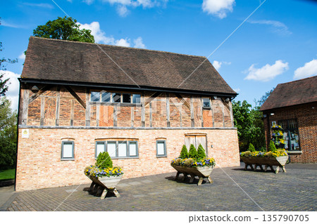 A historic red brick building under bright sunlight and a blue sky at Eastcote House in the suburbs of London A historic red brick building under bright sunlight and a blue sky at Eastcote House in the suburbs of London 135790705