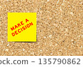 Yellow note paper with word make a decision on cork board background with copy space 135790862