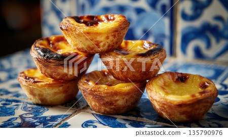 Pastel de nata tarts sitting on blue Portuguese azulejo tiles Pastel de nata tarts sitting on blue Portuguese azulejo tiles 135790976