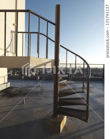 A spiral staircase on the rooftop bathed in the winter afternoon light and the expansive cityscape A spiral staircase on the rooftop bathed in the winter afternoon light and the expansive cityscape 135791137