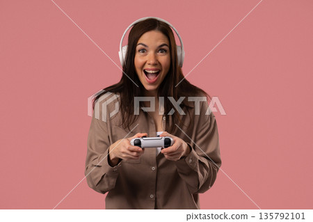 Young Female Gamer Celebrating Victory While Playing Video Games On Pink Studio Young Female Gamer Celebrating Victory While Playing Video Games On Pink Studio 135792101