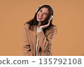 Happy Young Woman In Formal Jacket Listening Music, Dances Wireless Headphones 135792108