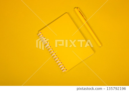Yellow pen and notebook on a yellow background Yellow pen and notebook on a yellow background 135792196