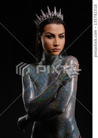 Powerful woman in a crown with her body covered in shimmering holographic glitter Powerful woman in a crown with her body covered in shimmering holographic glitter 135792318