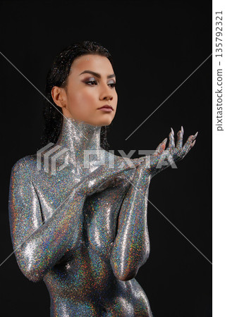 Elegant woman with silver glitter body art and makeup on a black background. 135792321