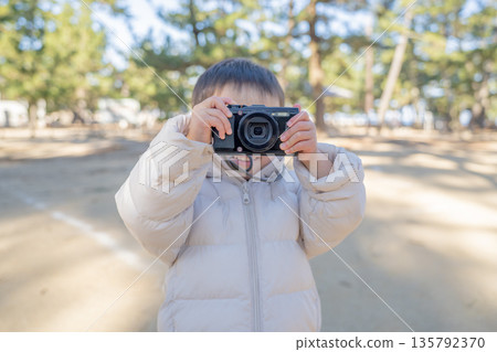 Boy taking a photo with a digital camera Boy taking a photo with a digital camera 135792370