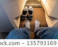 Inflight business class passenger with ample leg room took off shoes during flight for comfort travel 135793169
