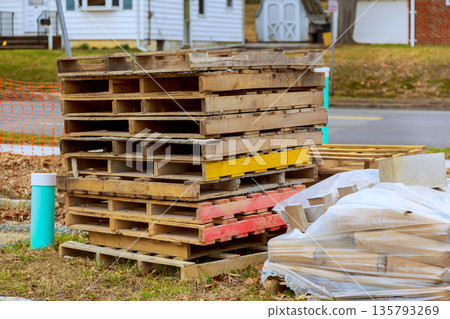 Stack of wooden pallets pile of bricks near construction site in suburban area 135793269